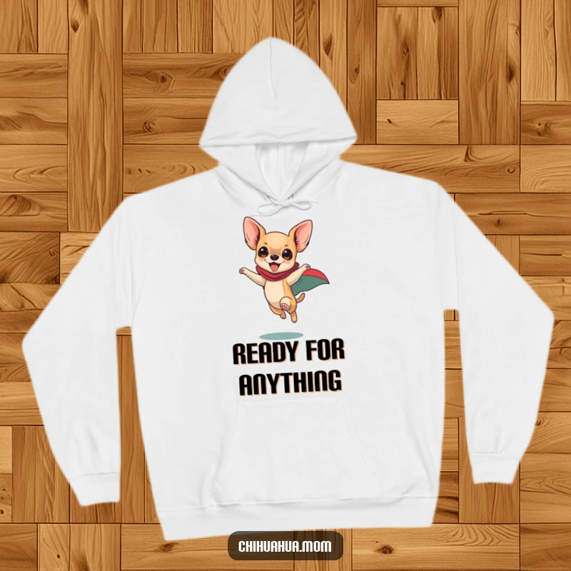 Funny Chihuahua Hoodie: Playful dog in superhero cape leaping with enthusiasm, warm heroic apparel, cozy pet lover.